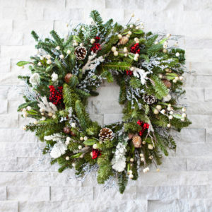 Christmas Wreath hung up on a white brick wall. 
