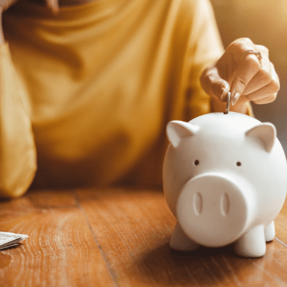 Photo of a girl putting a coin inside of a piggy bank. Things i wish i knew before getting my first apartment