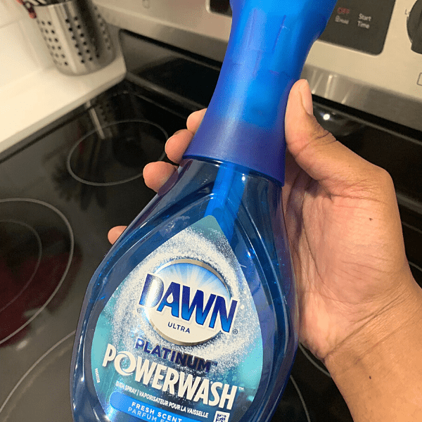 Person holding the dawn powerwash spray above the stove. Dawn powerwash uses.