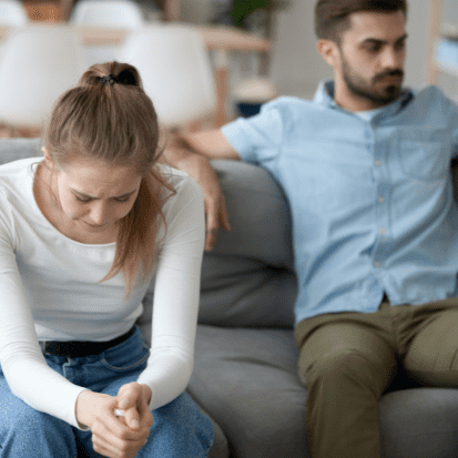 couple looking upset on the couch. How to tell if relationship is not working 