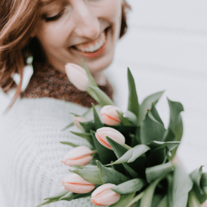 women holding tulips and smiling