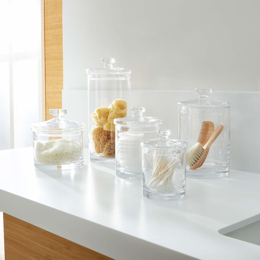Bathroom sink organizer. Photo of glass jars in various sizes on top of a bathroom sink 