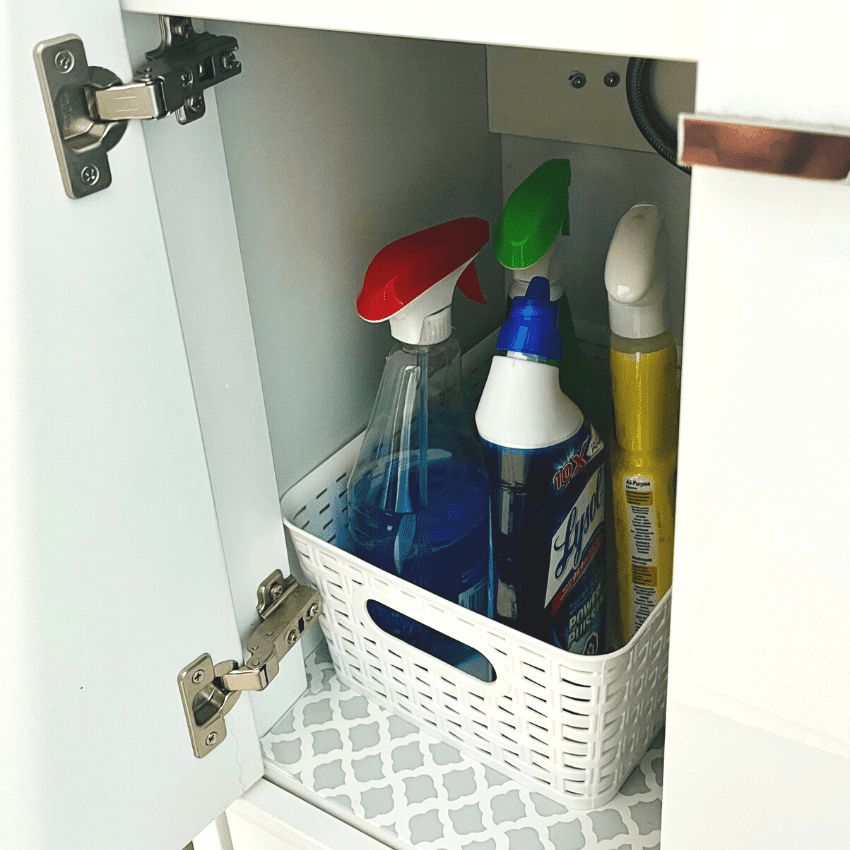 photo of cleaning products inside of plastic basket. Bathroom sink organization ideas. 