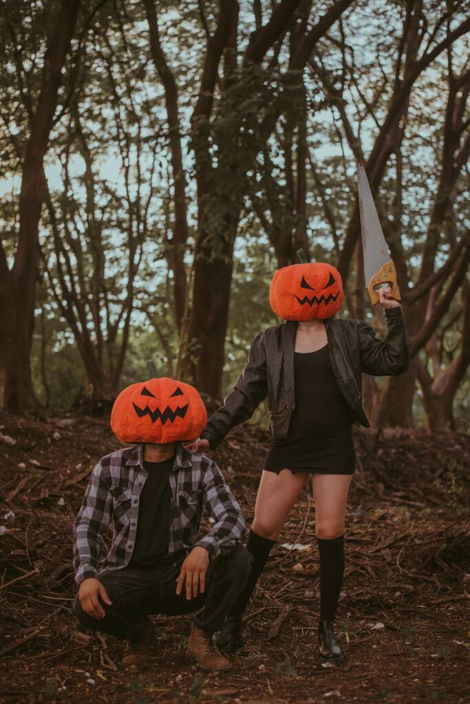 photo of a couple having a pumpkin head. guy holding a saw. Halloween costumes for couples