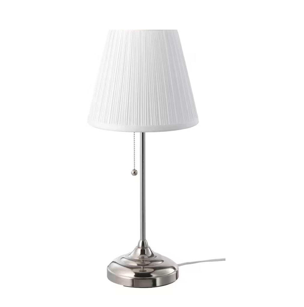 photo of a white and silver nightstand lamp from Ikea. First Apartment shopping List