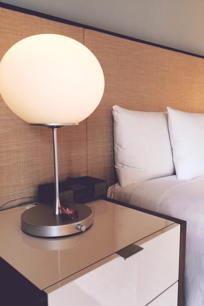 photo of a ed, a night stand and a sphere lamp. wedding budget breakdown.